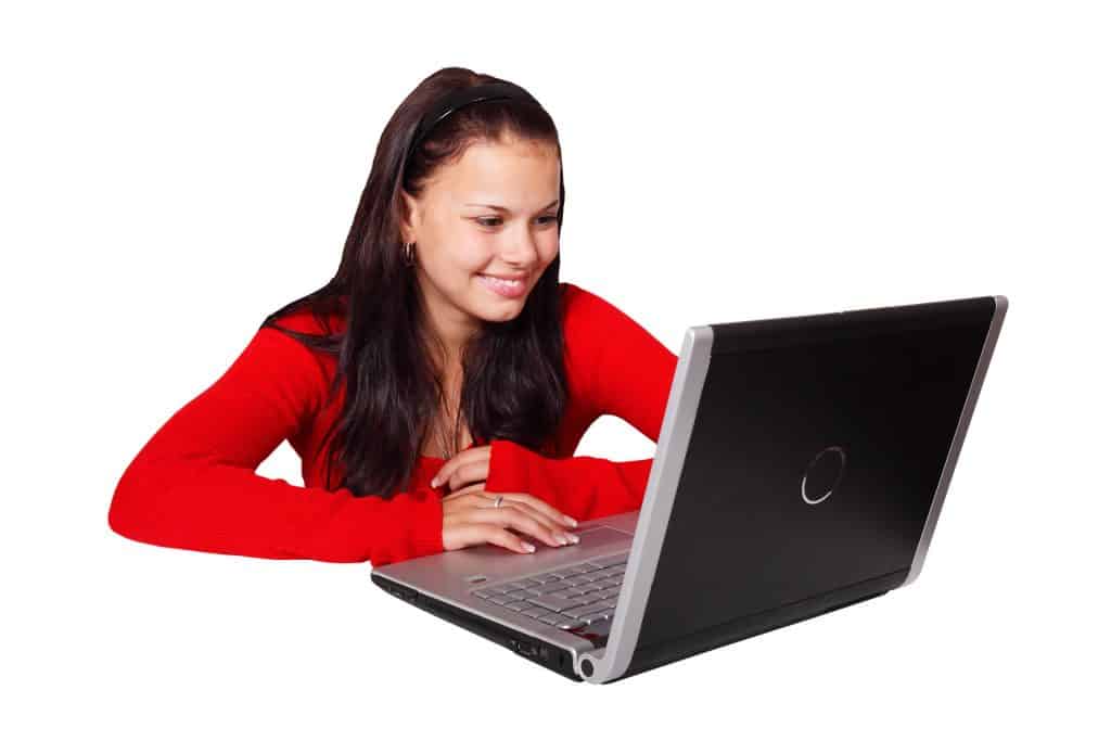 Woman using computer and smiling.
