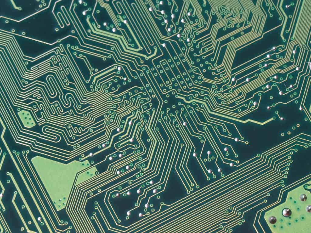 A close up view of a computer motherboard. The wire traces can be clearly seen.