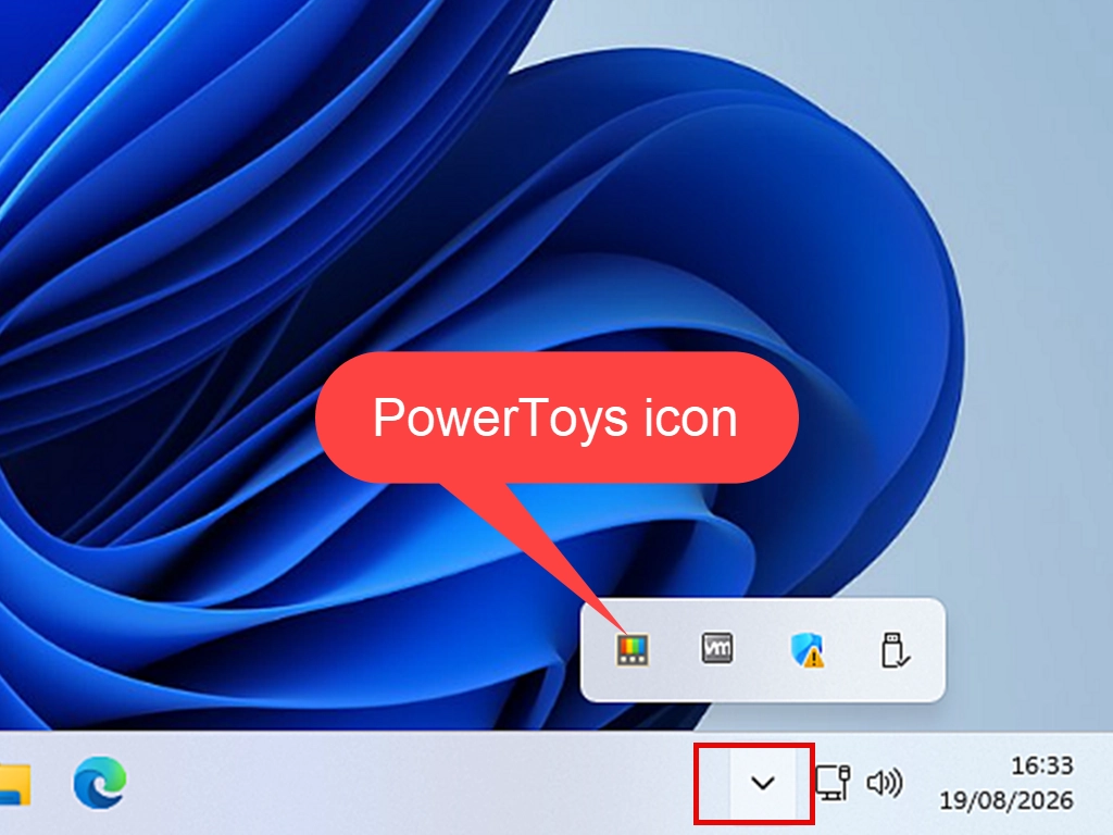The Windows taskbar with the hidden icons arrow expanded, showing the PowerToys icon